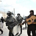Διαδηλωτής παίζει κιθάρα δίπλα στα ΜΑΤ τη στιγμή των επεισοδίων στο Σύνταγμα (vid)