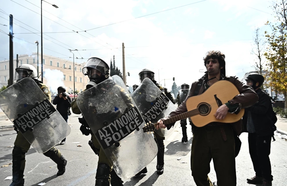 Διαδηλωτής παίζει κιθάρα δίπλα στα ΜΑΤ τη στιγμή των επεισοδίων στο Σύνταγμα (vid)